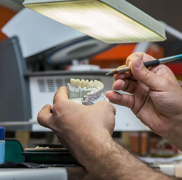 técnico de laboratorio moldeando prótesis